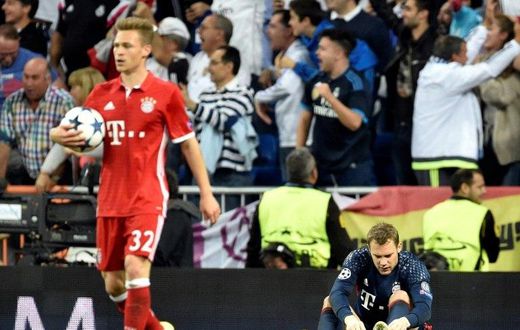 Bayern Munich goalkeeper Manuel Neuer (R) removes his boot during the Champions League quarter-final second leg against Real Madrid at the Santiago Bernabeu stadium in Madrid on April 18, 2017