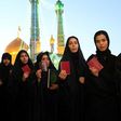Iranian women hold their IDs as they wait to vote at the Massoumeh shrine in the holy city of Qom on May 19, 2017