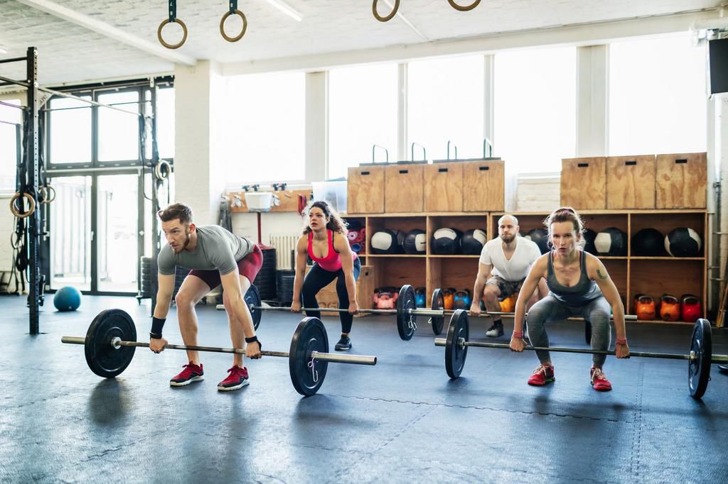 Group Of Gym Goers Weight Training Together