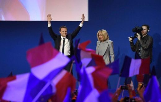 Emmanuel Macron and his wife Brigitte Trogneux salute the crowd after projections indicated the 39-year-old centrist led first round voting in France's presidential elections