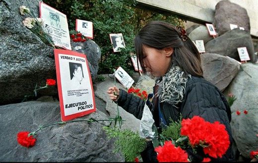A relative of the Caravan of Death incident places flowers in the Memorial to the Detained and Disappeared at the Santiago cemetery, on July 21, 1999