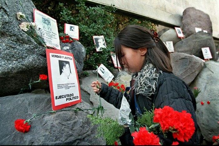 A relative of the Caravan of Death incident places flowers in the Memorial to the Detained and Disappeared at the Santiago cemetery, on July 21, 1999