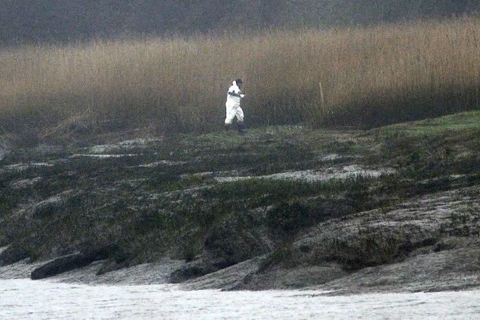 A police officer searches an area on March 8, 2017 in Pont-de-Buis, western France as part of a family murder investigation