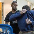 A US-Israeli Jewish teenager accused of making dozens of anti-Semitic bomb threats in the United States and elsewhere is escorted by guards as he leaves an Israeli court after his arrest