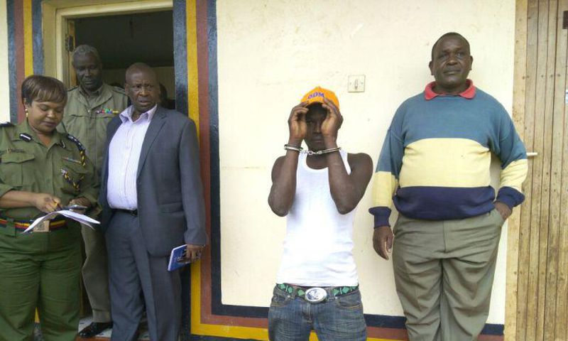 Julius Mwithalii (in handcuffs) after he was arrested for clinging on to Raila's chopper in Meru.