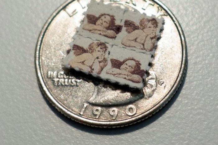 LSD blotter tabs on a US quarter coin, used as part of an illegal and potentially risky trend, of taking tiny amounts of psychedelic drugs too boost work or treat ailments