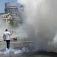 A man takes pictures as workers clash with the riot police during a protest against the Pension Fund Administrators (AFP) - Chile's privatized pension system - in front of the La Moneda presidential palace in Santiago, on November 4, 2016