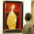 A visitor looks at the painting "Woman with a Fan" by Amedeo Modigliani -- one of five paintings discovered missing on May 20, 2010 at the Paris Musee d'Art Moderne (Modern Art Museum)
