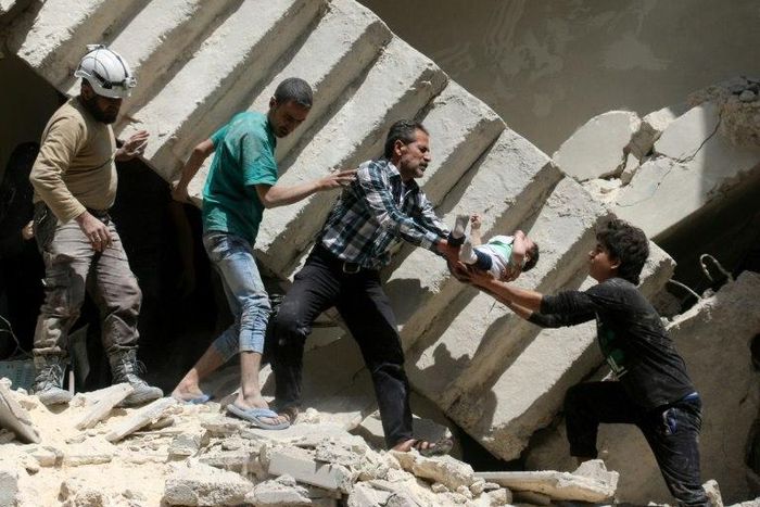 Syrian rescuers remove a baby from under rubble in al-Kalasa in northern Aleppo in April last year