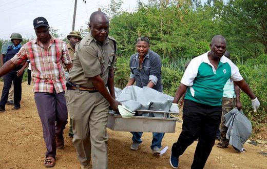 Policemen carry the dead bodies