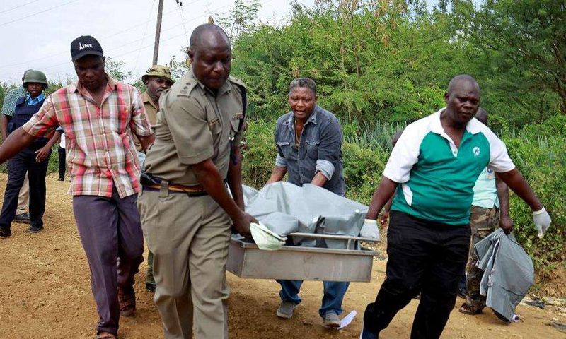 Policemen carry the dead bodies