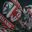 AC Milan supporters wave flags during a serie A match against Juventus