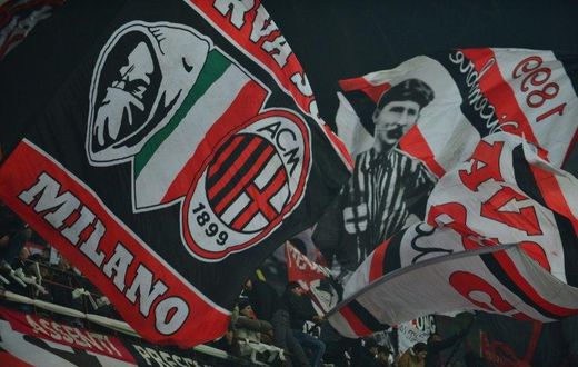AC Milan supporters wave flags during a serie A match against Juventus