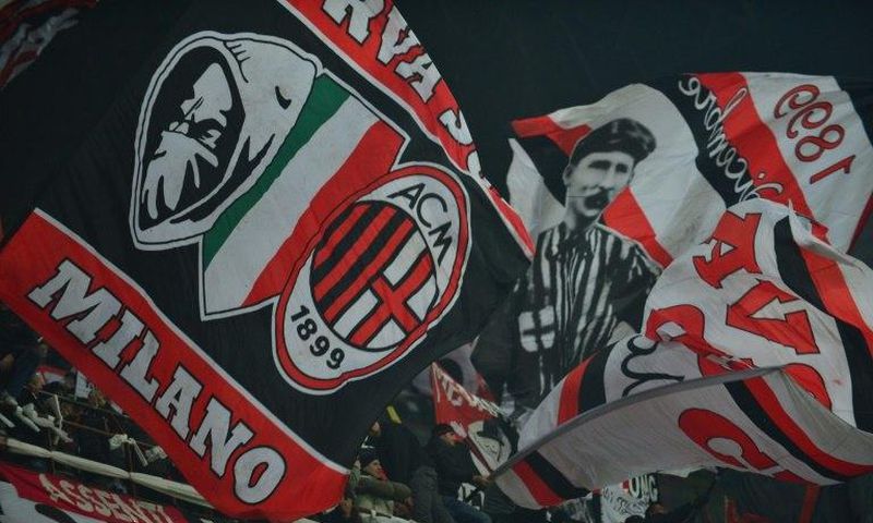AC Milan supporters wave flags during a serie A match against Juventus