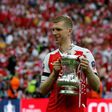 Arsenal's defender Per Mertesacker holds the trophy as he celebrates on the pitch after their win over Chelsea in the English FA Cup final on May 27, 2017