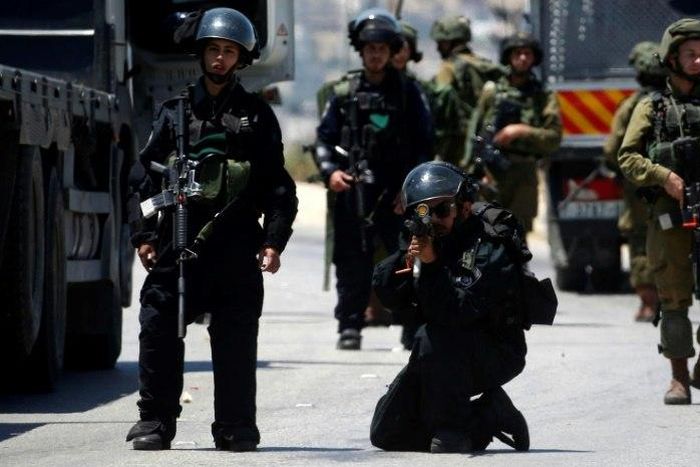Israeli forces take up positions during clashes with Palestinian protesters in the West Bank village of Beit Furik, east of Nablus, on May 12, 2017