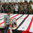 A Syrian boy places a picture on top of a coffin during a funeral ceremony at the Sayyida Zeinab shrine on the outskirts of Damascus on April 26, 2017 for victims of a bombing targeting evacuees from besieged government-held towns