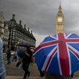 A pedestrian shelters from the rain near the Big Ben clock on June 25, 2016, following the result of the UK's EU referendum vote