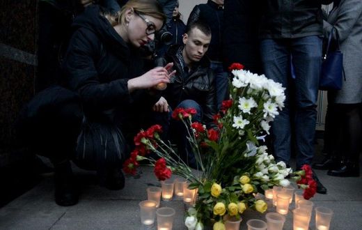 People place flowers and lit candles in memory of victims of the blast in the Saint Petersburg metro outside Sennaya Square station on April 3, 2017