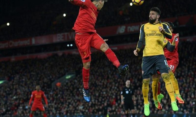 Liverpool's midfielder Roberto Firmino (C) heads the ball across goal during the English Premier League football match against Arsenal March 4, 2017