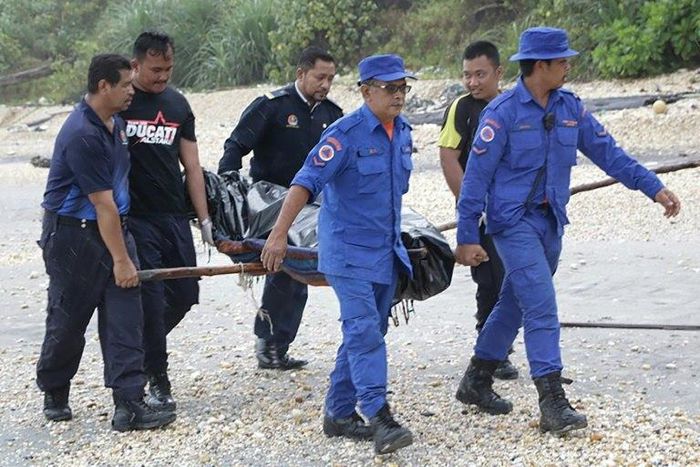 Rescuers carry a body retrieved from near the area where a boat carrying Indonesian immigrants capsized in Mersing, in Malaysia's southern Johor state in January