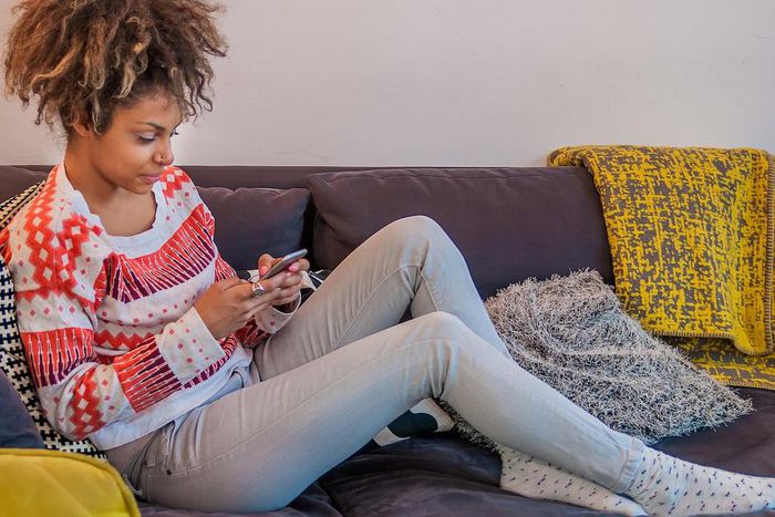 woman texting on couch