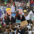 People carry effigies of US President Donald Trump (L) and Belgian Prime Minister Charles Michel during a demonstration against the US president in Brussels