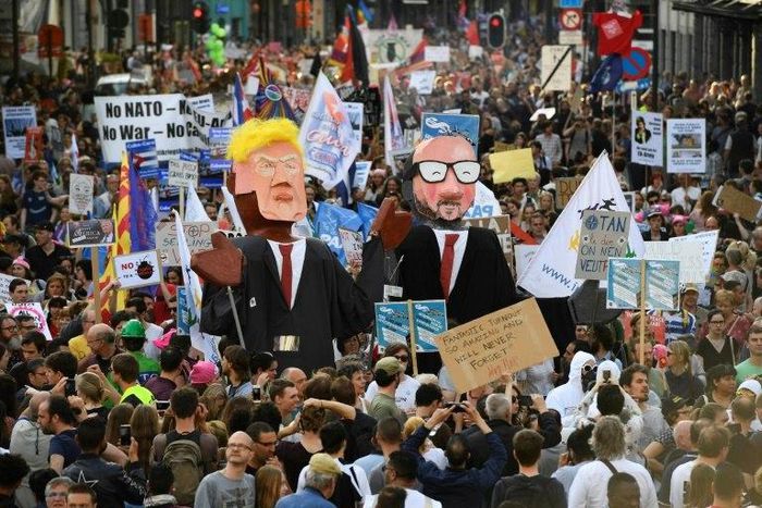 People carry effigies of US President Donald Trump (L) and Belgian Prime Minister Charles Michel during a demonstration against the US president in Brussels