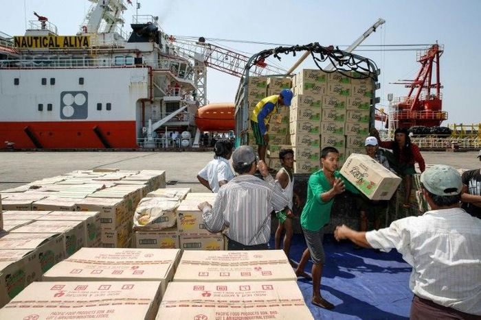 Myanmar workers load boxes of relief aid for Rohingya Muslims delivered by the humanitarian aid Malaysian ship Nautical Aliya in Yangon's Thilawa port on February 10, 2017