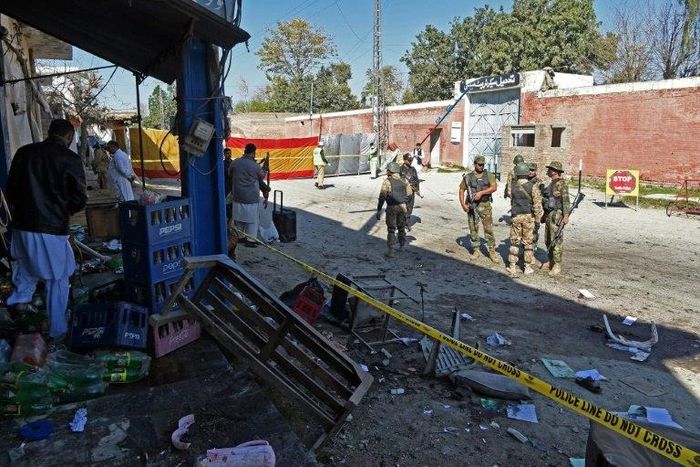 Pakistani soldiers stand guard at the site of a court complex in Tangi after multiple Taliban suicide bombings on February 21, 2017