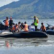 Volunteers pour water on pilot whales during a mass stranding at Farewell Spit, on February 11, 2017