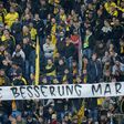Fans hold a banner reading "Get well Marc" ahead the UEFA Champions League 1st leg quarter-final football match BVB Borussia Dortmund v Monaco in Dortmund, western Germany on April 12, 2017