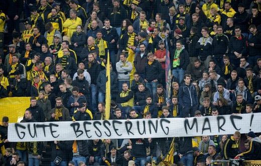 Fans hold a banner reading "Get well Marc" ahead the UEFA Champions League 1st leg quarter-final football match BVB Borussia Dortmund v Monaco in Dortmund, western Germany on April 12, 2017
