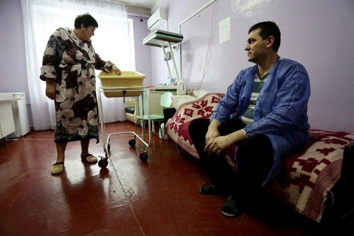 Ukranian woman Olena Gorbatova (L), plays with her baby as her husband Sergiy (R) looks on at the maternity hospital in the war-torn eastern city of Avdiivka.