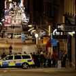People stand behind a cordon as police work at the scene of a truck attack that killed four people outside a busy department store in central Stockholm on April 7, 2017