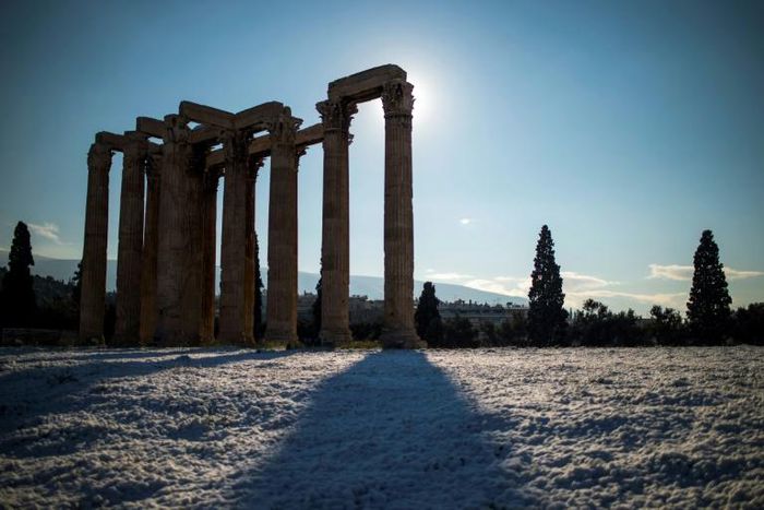 The ancient Temple of Zeus towers over an unusual blanketing of snow on Athens' Acropolis