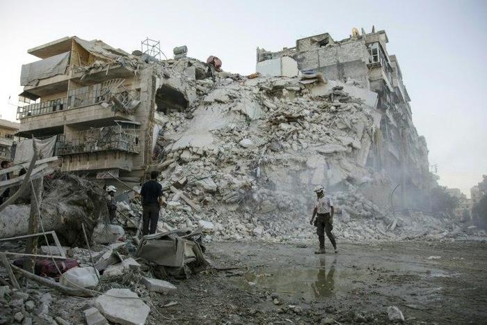 Members of the Syrian Civil Defence search for victims amid the rubble of a destroyed building in Aleppo, on October 17, 2016