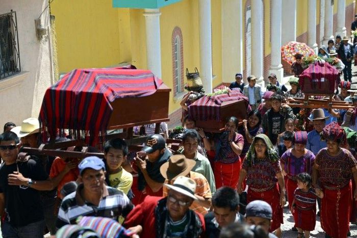 Mayan Ixil people carry coffins of victims of the 1982 Guatemala civil war massacre through Nebaj, in Quiche department, some 260 km northwest of Guatemala City on July 30, 2014