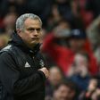 Manchester United manager Jose Mourinho points at the club badge as he leaves the pitch after his side's English Premier League win over Chelsea at Old Trafford in Manchester, north-west England, on April 16, 2017
