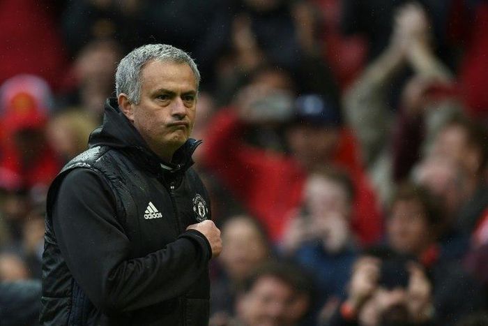 Manchester United manager Jose Mourinho points at the club badge as he leaves the pitch after his side's English Premier League win over Chelsea at Old Trafford in Manchester, north-west England, on April 16, 2017