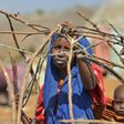 A woman builds a shelter at a makeshift camp on the outskirts of Baidoa, in the southwestern Bay region of Somalia