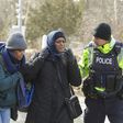 An RCMP officer speaks with women from Sudan after they illegally crossed the Canada-US border near Hemmingford, Quebec