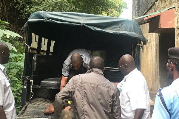 File image of police officers loading the remains of a dead person onto a vehicle