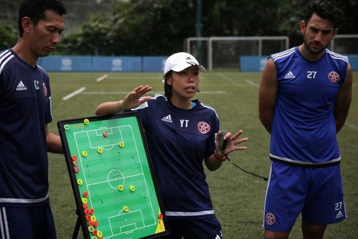 Head coach of Eastern FC, Chan Yuen-ting, talks to her players during a training session in Hong Kong