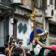 Egyptians raise a wooden cross and palm leaves as they gather outside the Coptic Christian patriarchate in the Mediterranean city of Alexandria where a jihadist bombing killed 17 people