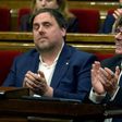 President of the Catalan regional Government Carles Puigdemont (R) and Catalan regional vice-president, Oriol Junqueras applaud after voting the Catalan government's 2017 budget at the Parliament of Catalonia on March 22, 2017 in Barcelona
