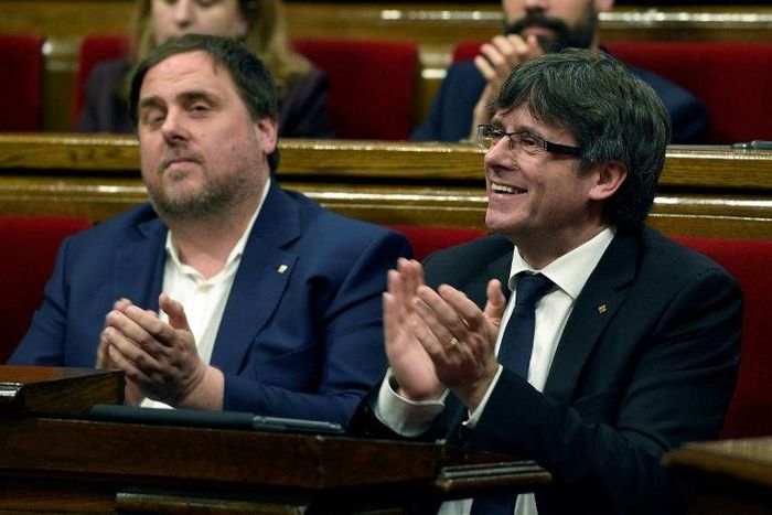 President of the Catalan regional Government Carles Puigdemont (R) and Catalan regional vice-president, Oriol Junqueras applaud after voting the Catalan government's 2017 budget at the Parliament of Catalonia on March 22, 2017 in Barcelona