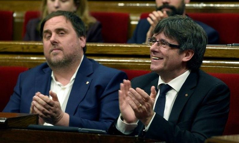 President of the Catalan regional Government Carles Puigdemont (R) and Catalan regional vice-president, Oriol Junqueras applaud after voting the Catalan government's 2017 budget at the Parliament of Catalonia on March 22, 2017 in Barcelona
