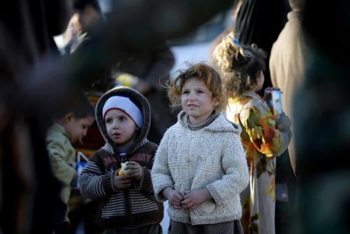 Displaced Iraqis who fled Mosul receive food and drink in Bartalla, east of Mosul