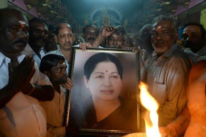 Supporters hold a photograph of Tamil Nadu state leader Jayalalithaa Jayaram as they offer prayers for her well being at a temple in Mumbai on December 5, 2016